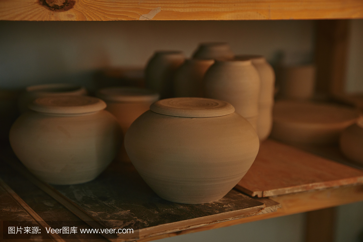 近距离观察陶瓷碗和盘子的木制架子在陶器工作室
